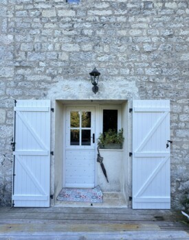 porte fermière et volets blancs sur façade en pierre